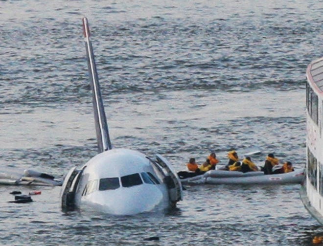 FILE - In this Jan. 15, 2009 file photo, passengers in an inflatable raft move away from an Airbus 320 US Airways aircraft that has gone down in the Hudson River in New York. More than seven years after an airline captain saved 155 lives by ditching his crippled airliner in the Hudson River, now the basis of a new movie, most of the safety recommendations stemming from the accident have yet to be followed. (AP Photo/Bebeto Matthews, File)