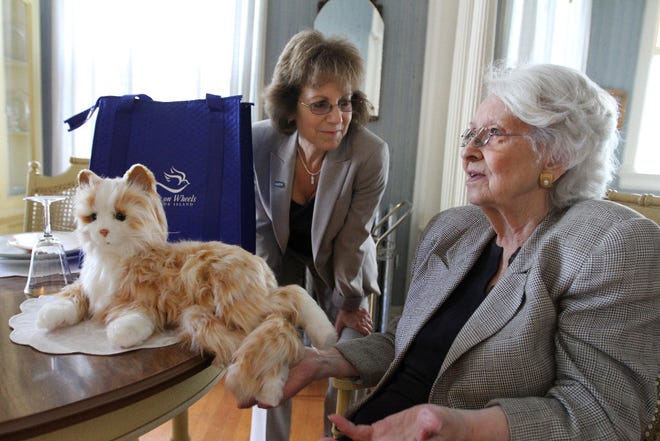 Ann Kondos, 82, of Providence talks with Ellie Hollander, president and CEO of Meals on Wheels America, after receiving a Joy For All Companion Pet cat, made by Hasbro.