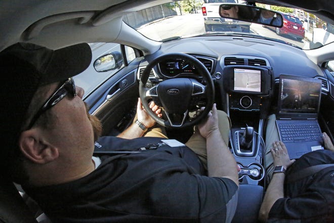Uber safety driver Zachary Rearick takes journalists on a drive Monday through the streets of downtown Pittsburgh in a self driving Uber car. Self-driving Ford Fusions began picking up volunteers in a test program Wednesday. ASSOCIATED PRESS / GENE J. PUSKAR