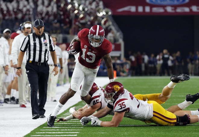 Alabama's ArDarius Stewart tries to avoid the tackles of USC's Cameron Smith, right, and Porter Gustin during a game Sept. 3. Tony Gutierrez/The Associated Press