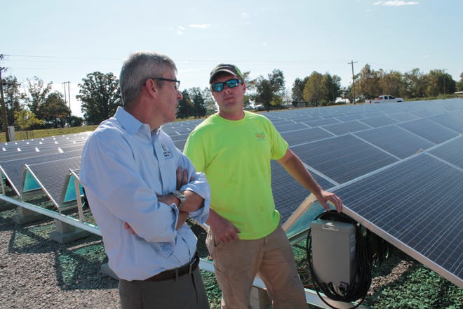 Greg Davis of Arkansas Valley Electric Cooperatives, left, speaks with Ryan Woodson of Today's Power Inc. on Wednesday next to a 500 kilowatt solar array near Van Buren. JOHN LOVETT/TIMES RECORD