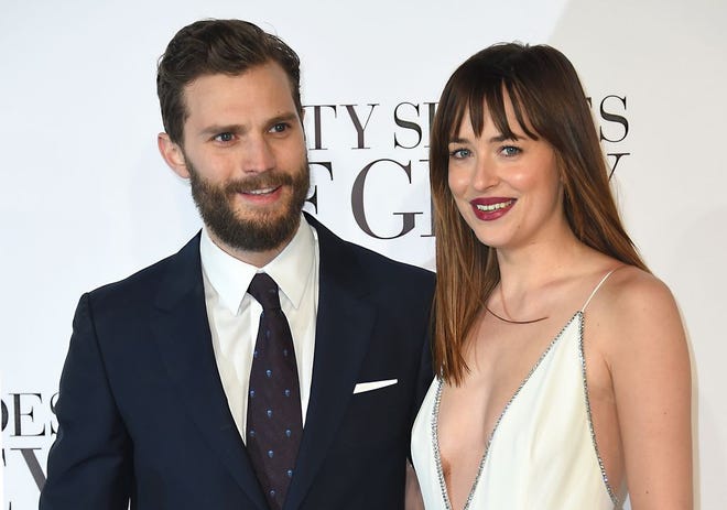 Actors Dakota Johnson, right, and Jamie Dornan pose for photographers at the UK Premiere of Fifty Shades of Grey, at a central London cinema on Feb. 12, 2015. (Photo by Jonathan Short/Invision/AP)