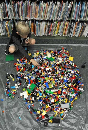 Bruce.Lipsky@jacksonville.com -- 09/13/16 -- Nathan Loos, 7, searches one of the large piles of LEGOs a specific piece for his creation. Green Cove Spring Public Library hosted the LEGO Jr. Maker's Club, for kids 5-12 years-old, on Tuesday, September 13, 2016, in Green Cove Springs, Florida. (Florida Times-Union, Bruce Lipsky)