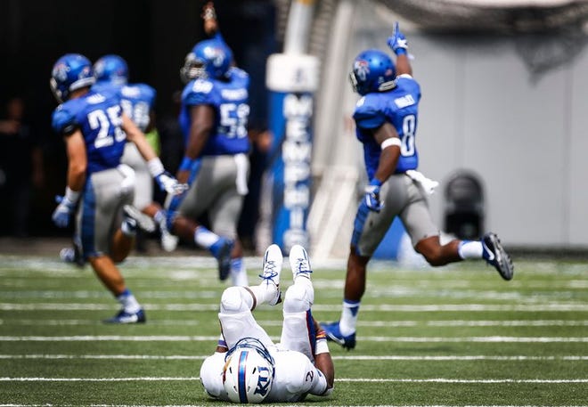 Kansas quarterback Montell Cozart lays on the field after throwing an interception for a touchdown against Memphis during the second quarter of Saturday's game at Liberty Bowl Memorial Stadium in Memphis, Tenn. The Jayhawks committed six turnovers in the 43-7 defeat.