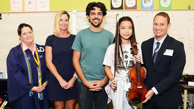 Madison Phoegun, a student at The Conservatory School @ North Palm Beach, received a refurbished century-old violin valued at $1,000 through Palm Beach Symphony’s instrument donation program. From left, Teresa Stoupas, principal; Kolleen Bylciw, Conservatory of North Palm Beach Foundation president; music teacher Victor Fenandez; Phoegun; and David McClymont, symphony executive director. Courtesy of Alissa Dragun, South Moon Photography