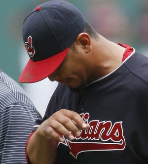 Cleveland Indians starting pitcher Carlos Carrasco walks off the field after suffering a broken right hand when he was hit by a ball off the bat of Detroit Tigers' Ian Kinsler during the first inning of a baseball game Saturday, Sept. 17, 2016, in Cleveland. (AP Photo/Ron Schwane)