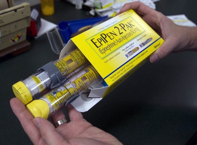 A pharmacist holds a package of EpiPens epinephrine auto-injector, a Mylan product. (AP Photo/Rich Pedroncelli, File)