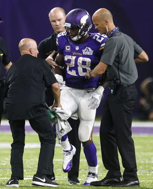 Minnesota Vikings running back Adrian Peterson (28) is helped off the field after getting injured during Sunday's game against the Green Bay Packers in Minneapolis. 

Jim Mone/Associated Press