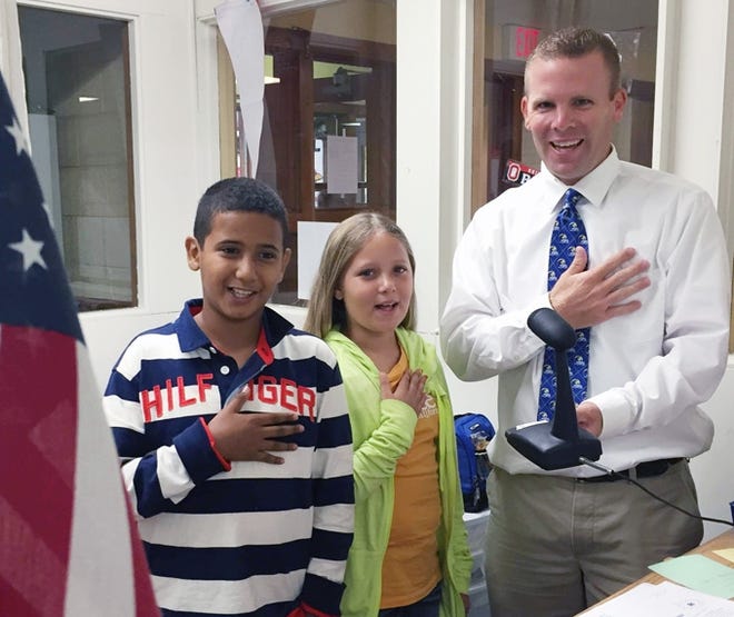 Lakeland Principal Gary Dancer recites the Pledge with two students over the school's intercom. Courtesy Photo
