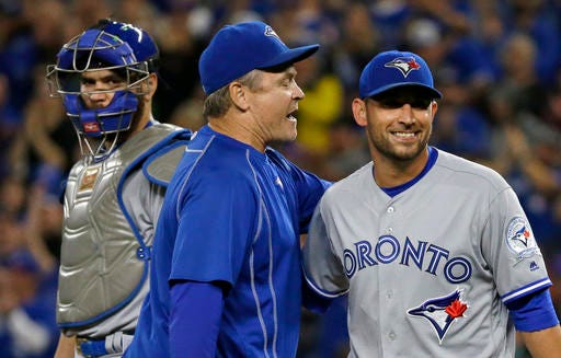 Toronto Blue Jays manager John Gibbons, center, smiles as he talks to starting pitcher Marco Estrada, right, after pulling him in the eighth inning of a baseball game against the Seattle Mariners as catcher Russell Martin looks on at left, Monday, Sept. 19, 2016, in Seattle. (AP Photo/Ted S. Warren)