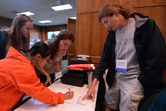 Lindsey Addison gets attendees of the North Carolina Waterbird Society Conference signed up for field trips to see the natural areas of North Carolina at the New Bern Convention Center, Sept 20, 2016.