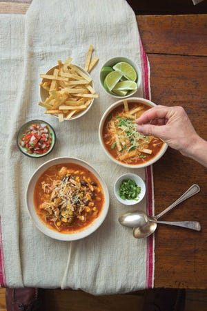 This July 2014 photo shows Mexican tortilla soup in New York. This dish is from a recipe by Katie Workman. (Todd Coleman via AP)