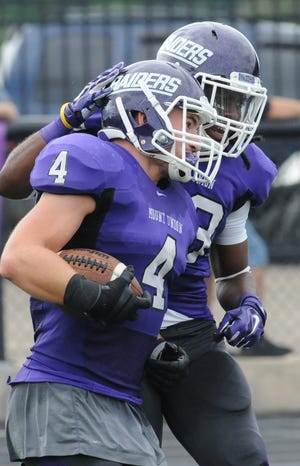 Mount Union's Danny Robinson (4) celebrates with teammate Jordan Hargrove after he returned an interception 76 yards for a touchdown during last week's 56-0 win over Marietta. (Michael Balash / Cantonrep.com)