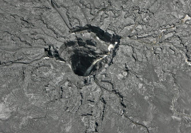This aerial photo shows a massive sinkhole last Friday in Mulberry, Fla., that opened up underneath a gypsum stack at a Mosaic phosphate fertilizer plant. Tens of millions of gallons of reprocessed water from the fertilizer plant in central Florida are likely to have seeped into the Floridan aquifer after the massive sinkhole opened up. (Jim Damaske/Tampa Bay Times via AP)