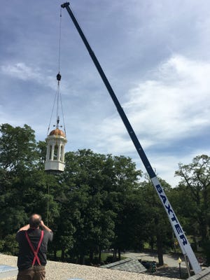 Cape Cod Builders on Sept. 21 removed the iconic Bourne Public Library cupola for repairs at Sandwich Road. The project includes re-mortaring brickwork, roof repairs, and painting the trim. 

Courtesy photo