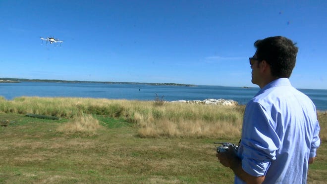 In this Thursday, Sept. 22, 2016 still image from video, aerospace engineer Felipe Bohorquez guides a test drone making a UPS delivery to Children's Island in Marblehead, Mass. UPS partnered with robot-maker CyPhy Works to fly the drone on a programmed route for three miles over the Atlantic Ocean to make the delivery. (AP Photo/Rodrique Ngowi)
