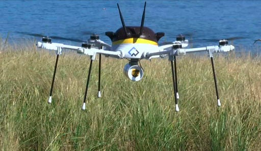 In this Thursday, Sept. 22, 2016 still image from video, a test drone making a UPS delivery lands on Children's Island in Marblehead, Mass. UPS partnered with robot-maker CyPhy Works to fly the drone on a programmed route for three miles over the Atlantic Ocean to make the delivery.