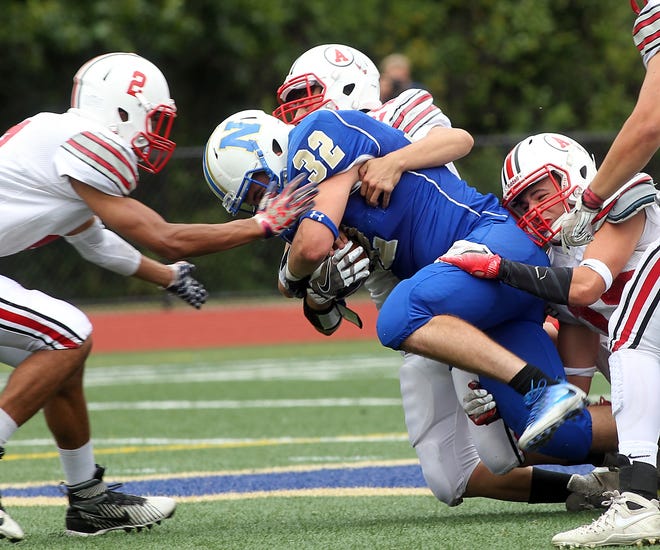 It takes a village that includes Amesbury's Zachary Prentiss and Daniel Nunes to take down Christian Mudge during a run in the second quarter of their game on Saturday, Sept. 10, 2016. Wicked Local Staff Photo/ Robin Chan