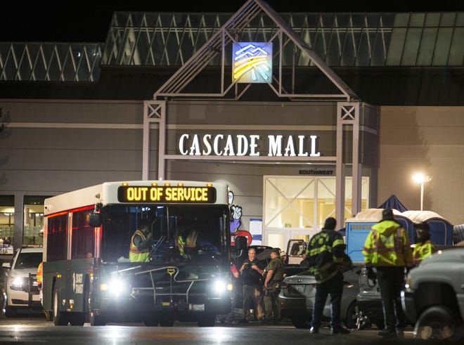 Emergency personnel stand in front of an entrance to the Cascade Mall at the scene of a shooting where several people were killed Friday in Burlington, Wash. Police searched Saturday for a gunman who opened fire in the makeup department of a Macy's store at the mall north of Seattle before fleeing toward an interstate on foot, authorities said. ASSOCIATED PRESS / STEPHEN BRASHEAR