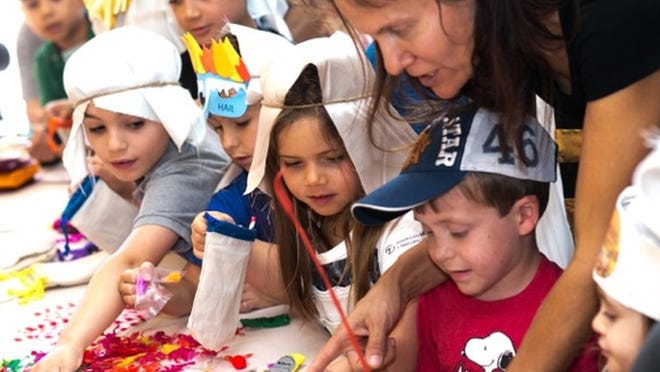 Children choose toys for their own “10 plague bag” to use at their Passover Seders at the Palm Beach Synagogue’s Passover Exodus Adventure for kids. From left are Michael Liberty, Landon McCoy, Breeze Dollinger, and Ruben Sigel with mom Serena Glazer Sigel.