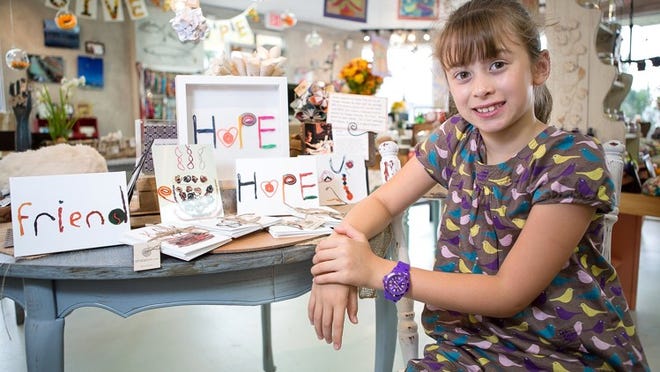 Anna Lutz, 8, of Palm Beach, shows her greeting cards at Shoppe 561 in West Palm Beach. A Palm Beach Public student, Anna created her own line of greeting cards after using Wikki Stix at The Breakers. She donates part of the proceeds to her favorite causes, including her school. (Madeline Gray / The Palm Beach Post)