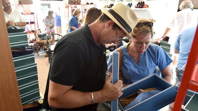 Scott Lankford and Dr. Ashley Lankford look for the perfect pair of Stubbs & Wooton shoes Monday during the half-off Day-After-Easter sale at the Via Parigi store.