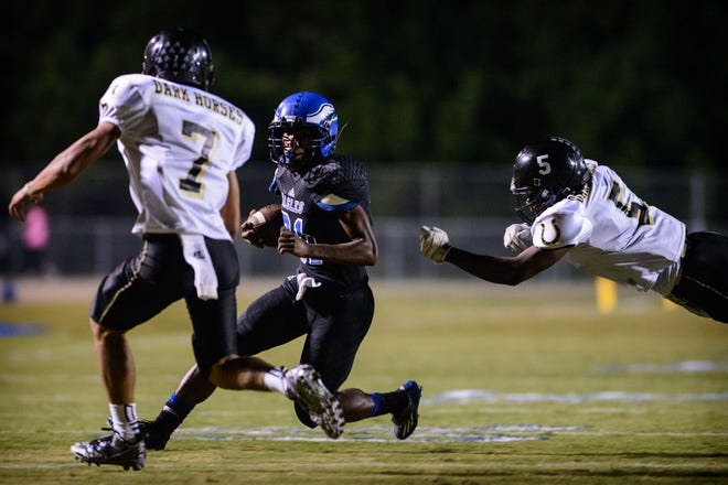 Clinton's Kris Royal, left, and Josh Armwood go after East Bladen's Ethan Hines during the first half Friday, Oct. 3, 2014, at East Bladen High School.