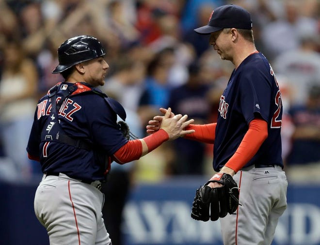 Boston Red Sox relief pitcher Brad Ziegler, right, shakes hands with catcher Christian Vazquez after closing out the Tampa Bay Rays during the ninth inning of a baseball game Friday, Sept. 23, 2016, in St. Petersburg, Fla. The Red Sox won the game 2-1. (AP Photo/Chris O'Meara)