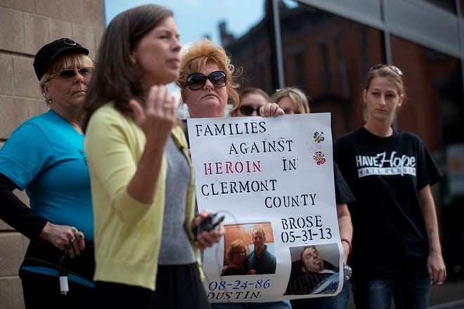 Carol DeMoss, center, holds a sign as State Rep. Denise Driehaus (D-Cincinnati), center left, speaks to the media on Sept. 11 during a rally on the steps of the Hamilton County Justice Center a wave of overdoses hit the region.