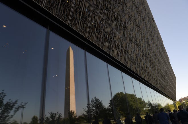 The Washington Monument is reflected in a window of the National Museum of African American History and Culture in Washington, D.C.