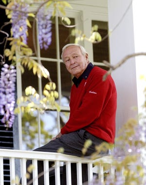 This 2004 file photo shows former Masters champion Arnold Palmer as he sits on clubhouse railing at the Augusta National Golf Club in Augusta, Ga. Palmer, who made golf popular for the masses with his hard-charging style, incomparable charisma and a personal touch that made him known throughout the golf world as “The King,” died Sunday, Sept. 25, 2016, in Pittsburgh. He was 87. (AP Photo/David J. Phillip, File)