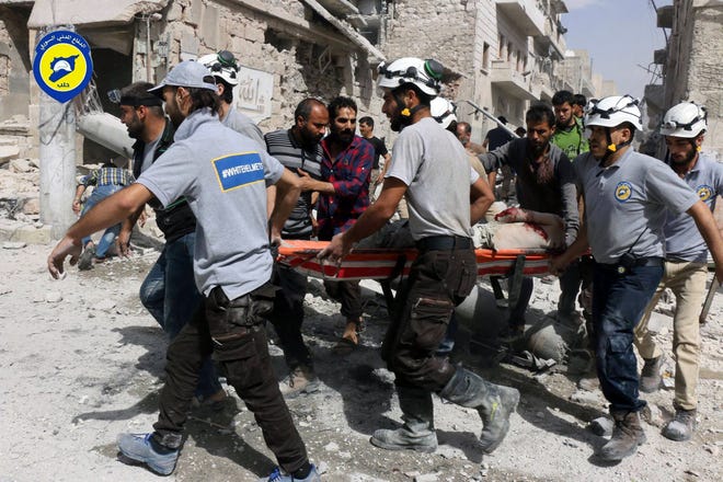 FILE - In this Wednesday, Sept. 21, 2016, file photo, provided by the Syrian Civil Defense White Helmets, rescue workers work the site of airstrikes in the al-Sakhour neighborhood of the rebel-held part of eastern Aleppo, Syria. Syrian Foreign Minister Walid al-Moallem said in a TV interview broadcast Monday, Sept. 26, 2016, that an internationally-brokered cease-fire for Syria is still viable, as rescue workers in Aleppo cleaned up from what they said were the worst airstrikes on rebel-held areas of the northern city in five years. Syria's military declared the cease-fire ended one week ago. (Syrian Civil Defense White Helmets via AP, File)