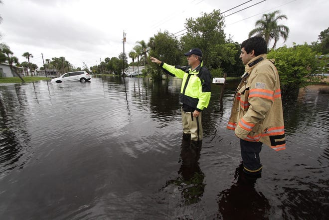 Sarasota County Emergency Management Chief Edward McCrane Jr., left and Danton Kerz survey flood damage from the Myaaka River in North Port in 2012. HERALD-TRIBUNE ARCHIVE