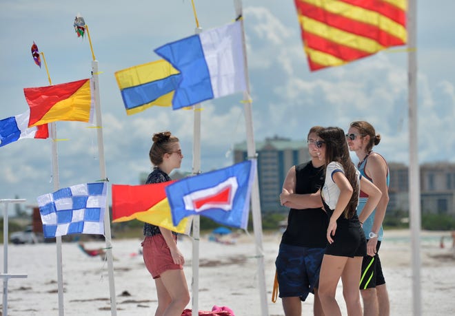 Ringling College of Art and Design students, from left, Hayley Denham, Steven Tacoronte, Jessica Iglesias and Stephen Parks stand near part of an environmental art installation on Lido Beach titled "Rise and Run." Herald-Tribune staff photo / Mike Lang