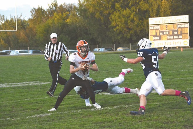 Sault High's Kyle Huskey (9) and Francis Scheid (58) chase Escanaba quarterback Justin Popelka (11) during a Great Northern Conference football game at VanCitters Field Friday night.