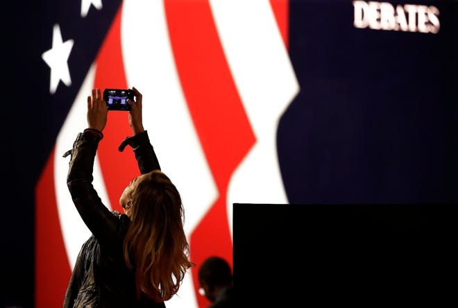 Lena Gjokaj takes a cell phone photo of stage for the presidential debate between Democratic presidential candidate Hillary Clinton and Republican presidential candidate Donald Trump at Hofstra University in Hempstead, N.Y., Monday, Sept. 26, 2016. (AP Photo/Julio Cortez)