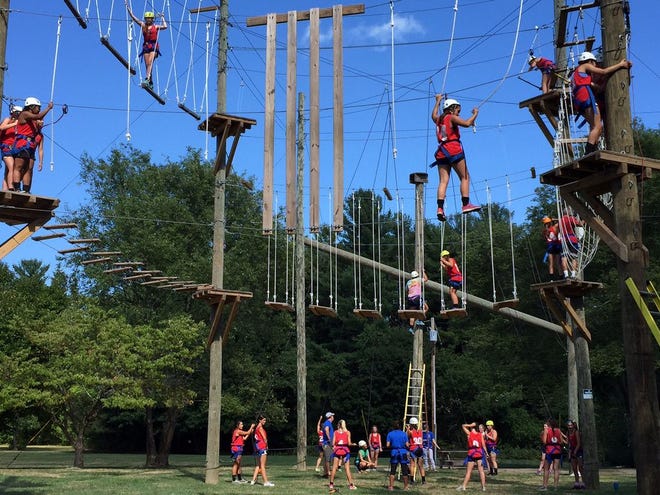 Members of the North Quincy High School girls' soccer team work out on the Norfolk County Sheriff's Department ropes course in Braintree