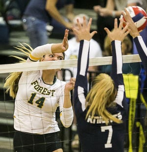 Forest's Cat Campbell spikes the ball over the net past Macenzi Monroe in the second set during the Wildcats' five-set win over Vanguard on Monday at VHS. MORE PHOTOS AT OCALA.COM (Doug Engle/Ocala Star-Banner)
