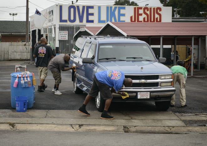 Workers clean a truck at the "Jesus Car Wash" on Eastern Boulevard in Fayetteville on Friday, Sept. 23, 2016. The car wash reopened following the death of its owner, Mike Mansfield.