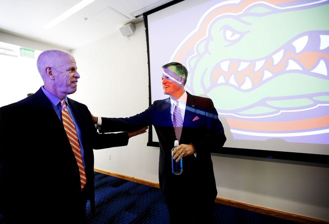 Outgoing Florida athletic director Jeremy Foley, left, congratulates incoming AD Scott Stricklin after a news conference Tuesday at the Hawkins Center at Farrior Hall auditorium on campus. Stricklin, who's been the athletic director at Mississippi State since 2010, will replace Foley by Nov. 1. Matt Stamey/Gainesville Sun