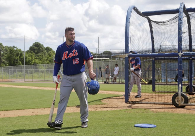 Tim Tebow grabs his gear at the end of practice at the New York Mets' complex Monday in Port St. Lucie. (AP Photo/Wilfredo Lee)