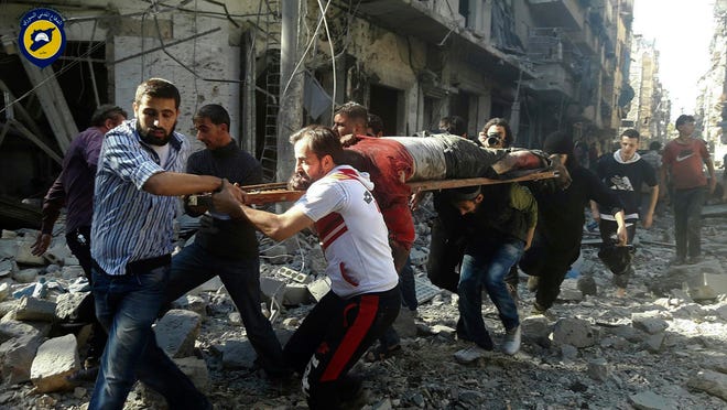 In this photo provided by the Syrian Civil Defense group known as the White Helmets, Syrians carry a victim after airstrikes by government helicopters on the rebel-held Aleppo neighborhood of Mashhad, Syria, Tuesday Sept. 27, 2016. With diplomacy in tatters and a month left to go before U.S. elections, the Syrian government and its Russian allies are using the time to try and recapture the northern city of Aleppo, mobilizing pro-government militias in the Old City and pressing ahead with the most destructive aerial campaign of the past five years. (Syrian Civil Defense White Helmets via AP)
