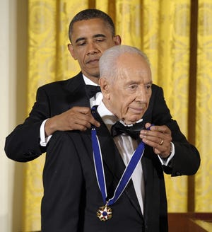 In this June 13, 2012, file photo, President Barack Obama awards Israeli President Shimon Peres with the Presidential Medal of Freedom at a dinner at the East Room of the White House in Washington. SUSAN WALSH/ASSOCIATED PRESS FILE PHOTO