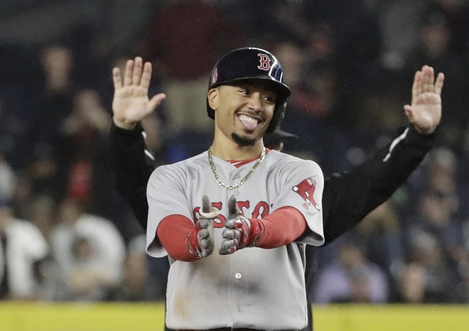 Red Sox right fielder Mookie Betts reacts after hitting a two-run double during the eighth inning of Boston's 5-3 loss to the Yankees on Wednesday night. The Red Sox clinched the A.L. East despite the defeat.