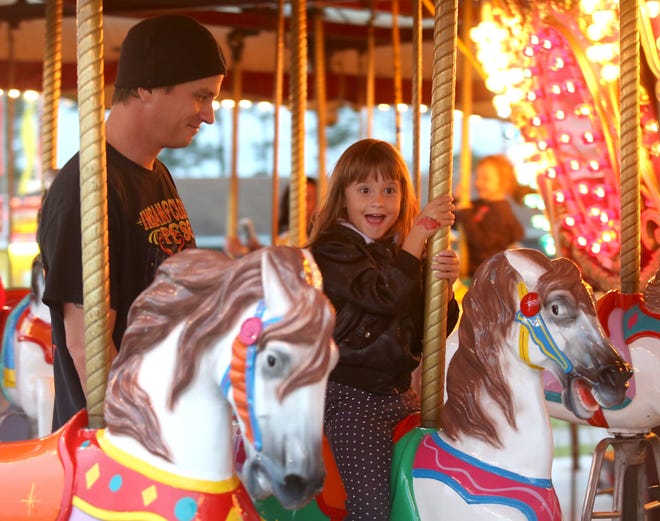 Mark Nichols watches his niece, 5-year-old Mary Jane Nichols ride a merry go round during the 2015 Central Panhandle Fair. This year's fair opens Oct. 3. PATTI BLAKE/The News Herald