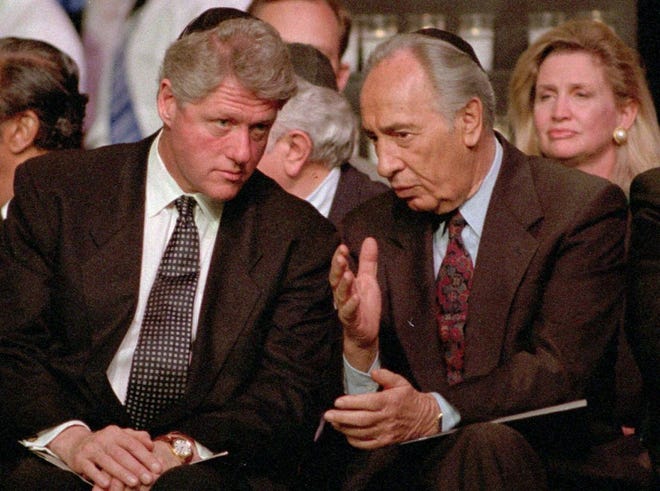 Then-President Bill Clinton, left, listens to then-Israeli Foreign Minister Shimon Peres at the American Gathering of Jewish Holocaust Survivors on Sunday, April 30, 1995, at the Paramount Theater in New York's Madison Square Garden. Peres, a former Israeli president and prime minister, has died. Clinton's campaign appearance has been canceled so the former president can attend Peres' funeral.