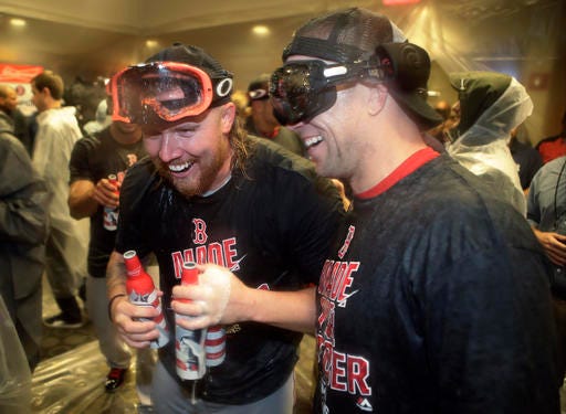 Boston Red Sox's Robbie Ross Jr., left, and Aaron Hill, right, celebrate with teammates after the Red Sox clinched the AL East title, following a baseball game against the New York Yankees on Wednesday, Sept. 28, 2016, in New York. (AP Photo/Frank Franklin II)