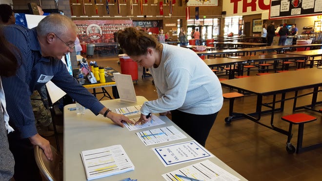 — Monroe News photo by ANDREA PECK

Monroe Township Clerk Bob Schnurr helps a Monroe High School student register to vote Tuesday, which marked National Voter Registration Day. The service was available during all lunches at the school.
