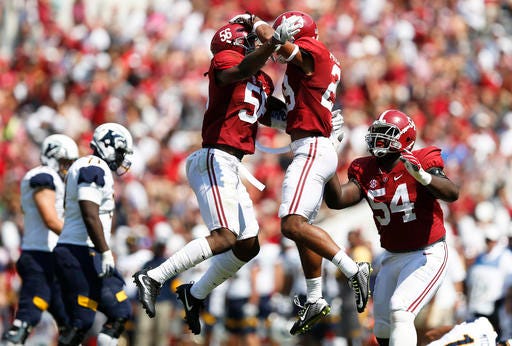 Alabama linebacker Tim Williams, left, defensive back Minkah Fitzpatrick, center and defensive lineman Dalvin Tomlinson celebrate after Fitzpatrick sacked Kent State quarterback Mylik Mitchell in the first half during an NCAA college football game, Saturday, Sept. 24, 2016, in Tuscaloosa, Ala. (AP Photo/Brynn Anderson)