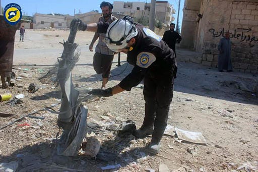 In this photo provided by the Syrian Civil Defense group known as the White Helmets, shows members of Civil Defense inspecting the cluster bombs in the Khan Sheikhoun neighborhood of Idlib, Syria, Thursday, Sept. 29, 2016. The U.S. and Russia escalated their war of words over Syria Thursday as government forces kept up their assault on Aleppo's rebel-held quarters and registered tenuous gains. (Syrian Civil Defense White Helmets via AP)